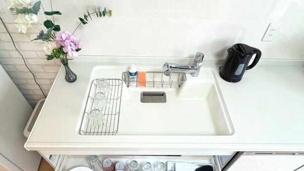 A kitchen with a white countertop, a sink, a kettle, and a drawer with dishes and utensils. - Kayo, Nijo Minami, 6 minutes walk from Nijo Station, quiet house (Kyoto)