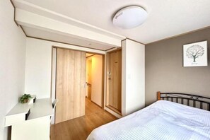 Un dormitorio con una cama, un escritorio y un armario.