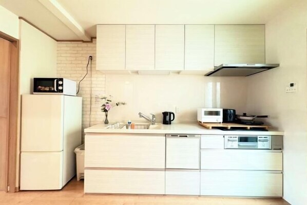 Cocina compacta con refrigerador, microondas, fregadero y estufa.