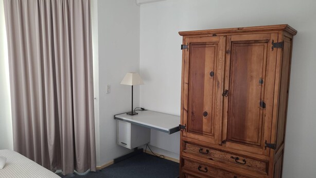 A room with a bed, a desk, a cabinet, and a lamp. - Vistá Piscaderá (Willemstad)
