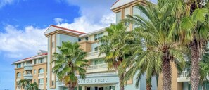 Un hôtel à plusieurs étages doté de balcons et de palmiers.