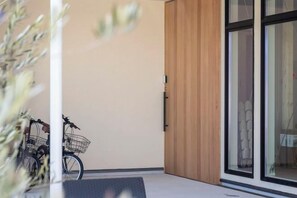 Una stanza con una porta a vetri scorrevoli, una bicicletta e una panca.