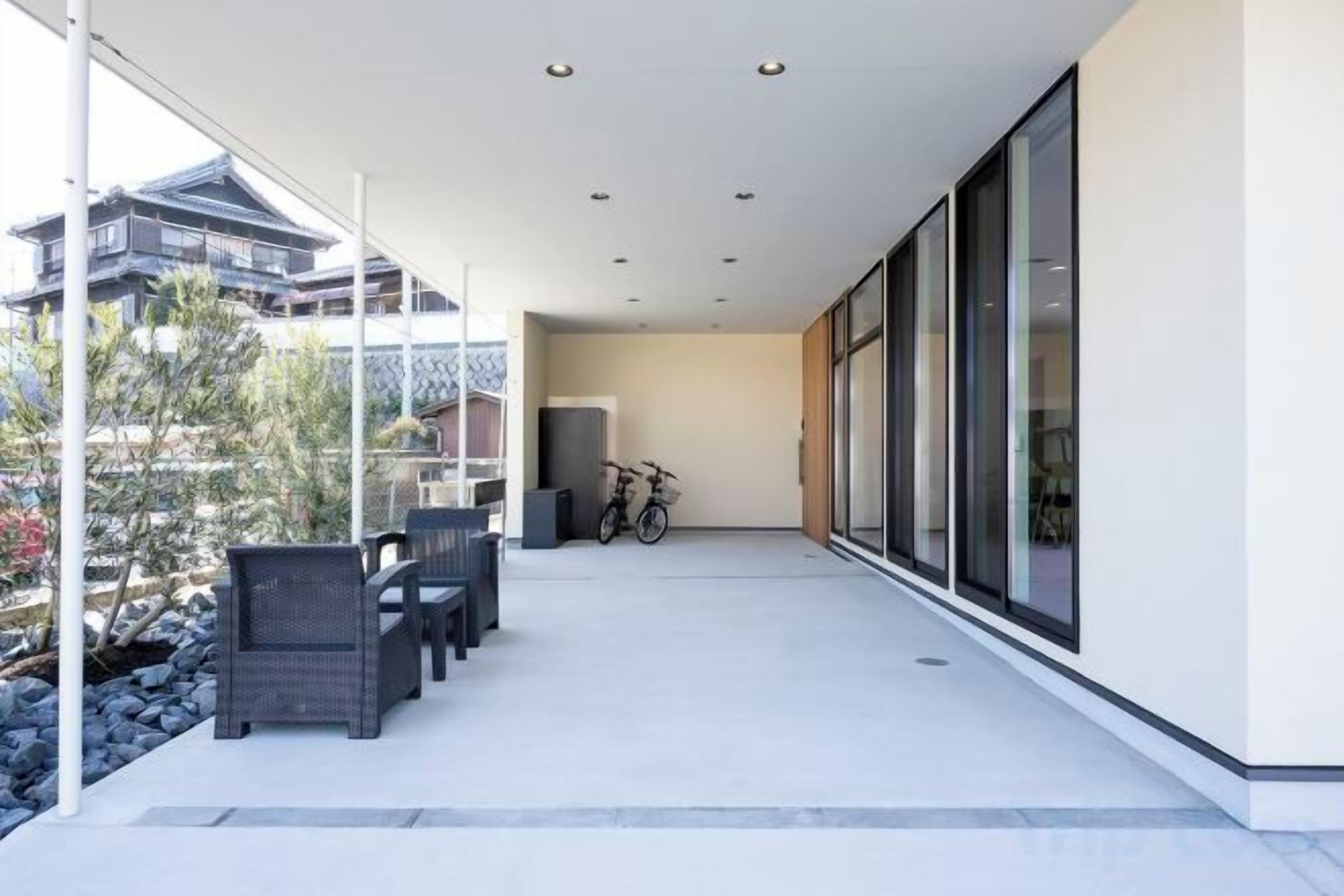 A modern outdoor patio with a seating area, a bicycle, and a view of traditional buildings.