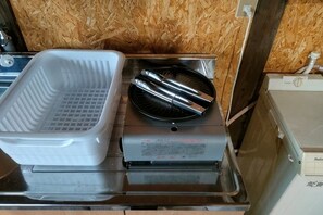 Una cocina con una bandeja blanca, una parrilla negra y un electrodoméstico de acero inoxidable.