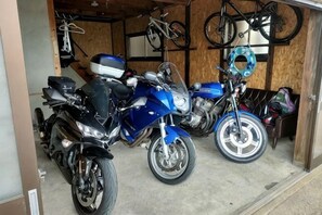 A motorcycle garage with two motorcycles, a helmet, and a bicycle rack. - 3 seconds to the sea [25 minutes drive to Ine no Funya] Scenic ocean view BBQ entire house rental (Kyotango)