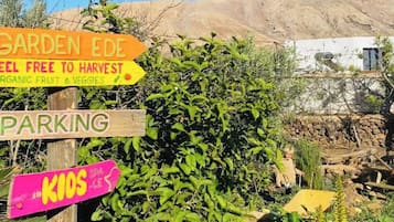 Un panel con indicaciones hacia jardín, estacionamiento y zona infantil.