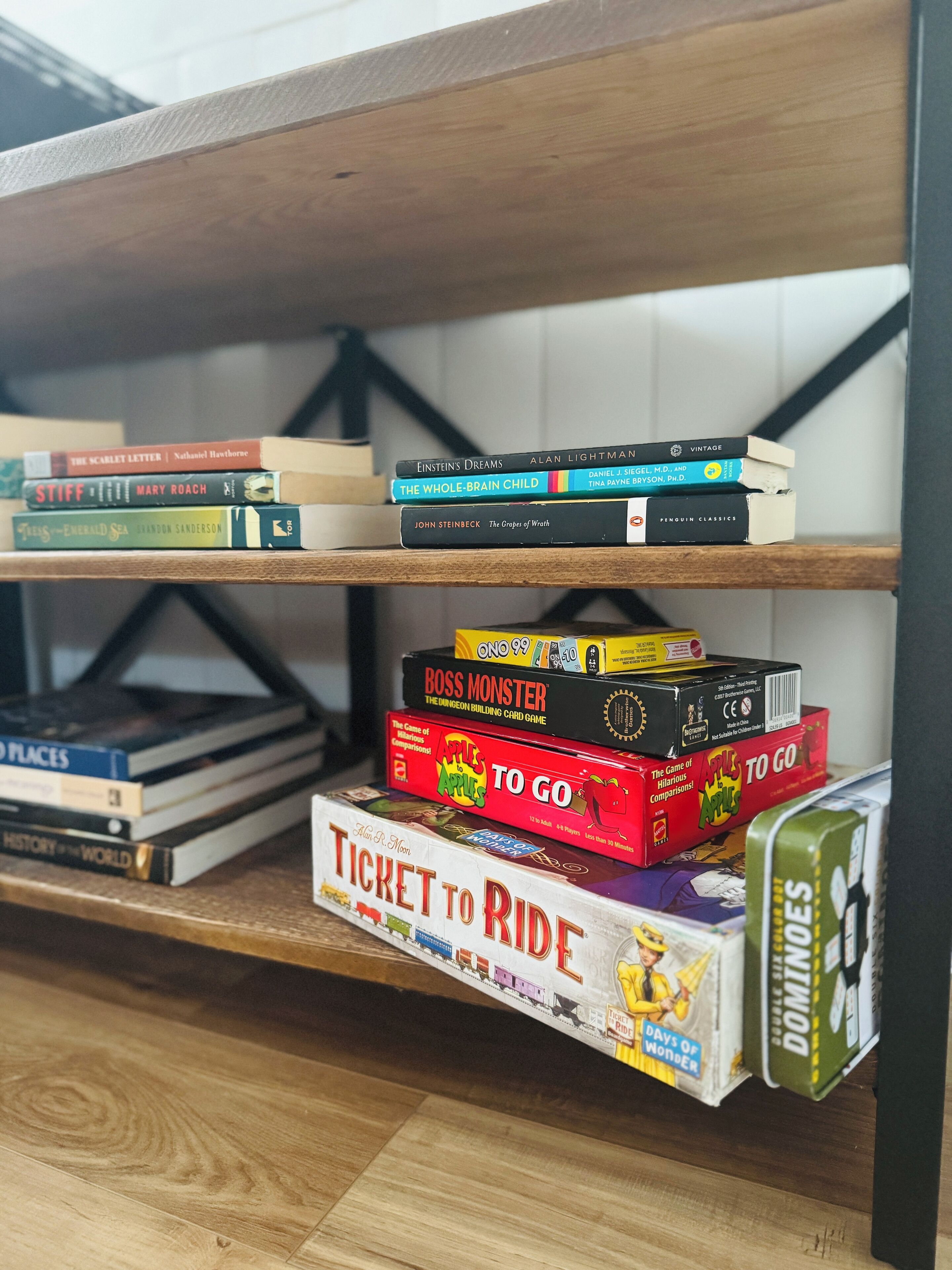 Una estantería con varios libros y juegos de mesa.