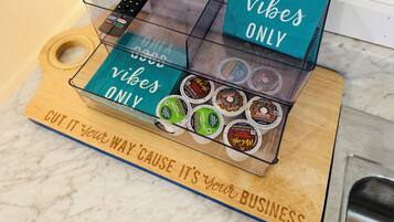 A coffee display with various brands and a sign that says "GOOD vibes ONLY".
