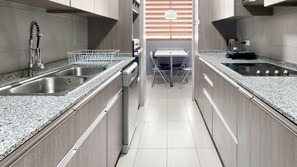 A modern kitchen with granite countertops, stainless steel appliances, and a central island with seating.