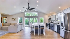 A spacious kitchen with a dining area, large windows, and a ceiling fan. - New Modern Construction on McNutt Lake, Minutes from downtown Minocqua! (Minocqua)