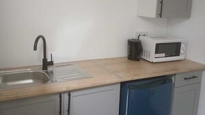 A compact kitchen with a sink, a microwave, and a dishwasher. - Ground-Floor Family Studio Apartment with Double and Single Beds – Free Parking (Gosport)