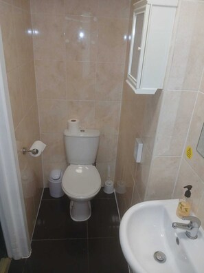 Un baño pequeño con inodoro, lavabo y espejo.