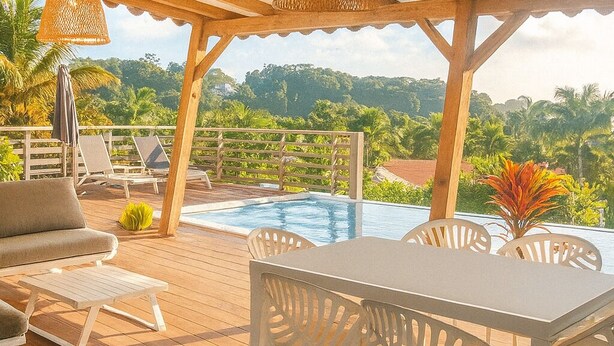 Area piscina esterna con pavimento in legno, arredi bianchi e luci a sospensione.