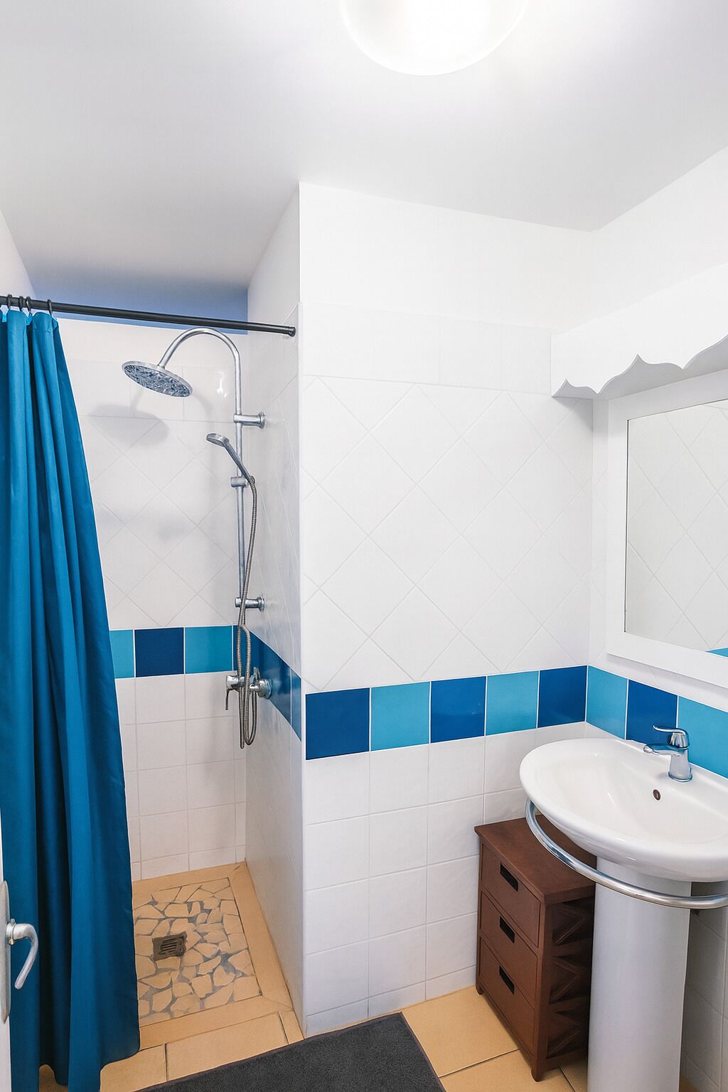Une salle de bain avec une douche, un lavabo et un miroir.