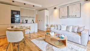 En moderne stue med sofa, sofabord og spiseområde.
