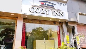The exterior of a hotel named "COZY INN" with a clear signboard, large windows, and a visible entrance. - Cozy Inn T2 Mumbai Airport (Mumbai)