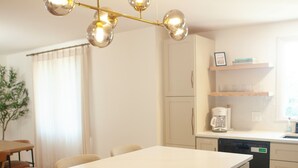 A modern kitchen with a central island, built-in oven, and a hanging light fixture. - Luxury 4-bedroom house with AC/Heat in Buffalo (Buffalo)
