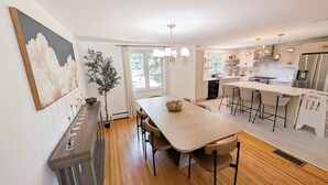 A modern kitchen with a central island, wooden flooring, and pendant lighting. - Luxury 4-bedroom house with AC/Heat in Buffalo (Buffalo)