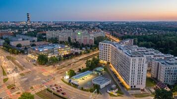 A multi-story building with a modern design, surrounded by roads and greenery.