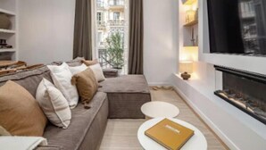Un salon chaleureux avec un canapé, une petite table ronde et une cheminée.