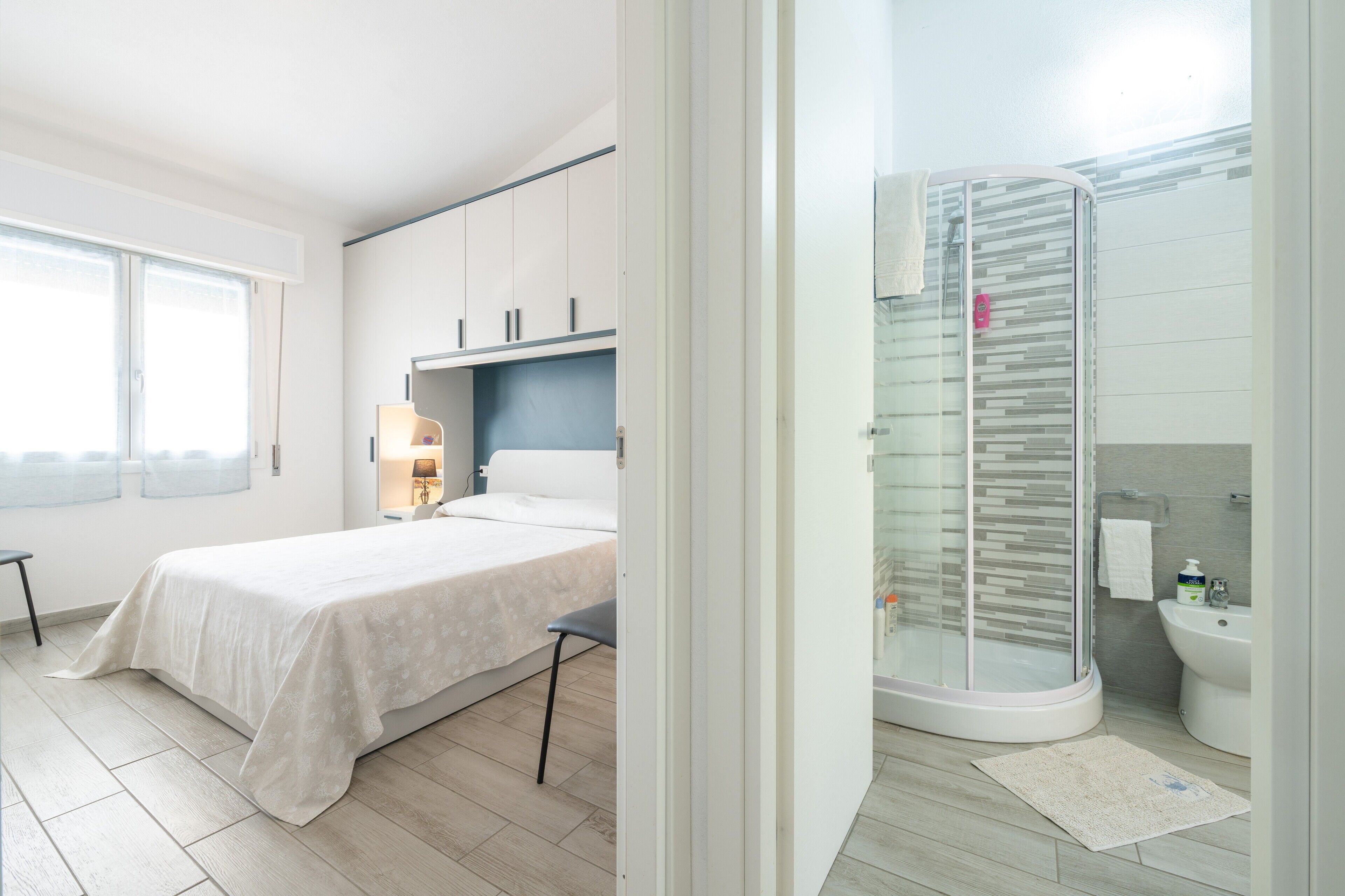 Une chambre moderne avec un lit, une table de chevet et une fenêtre.