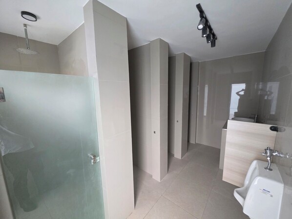 Un baño moderno con cabina de ducha de vidrio, tocador de madera y espejo.
