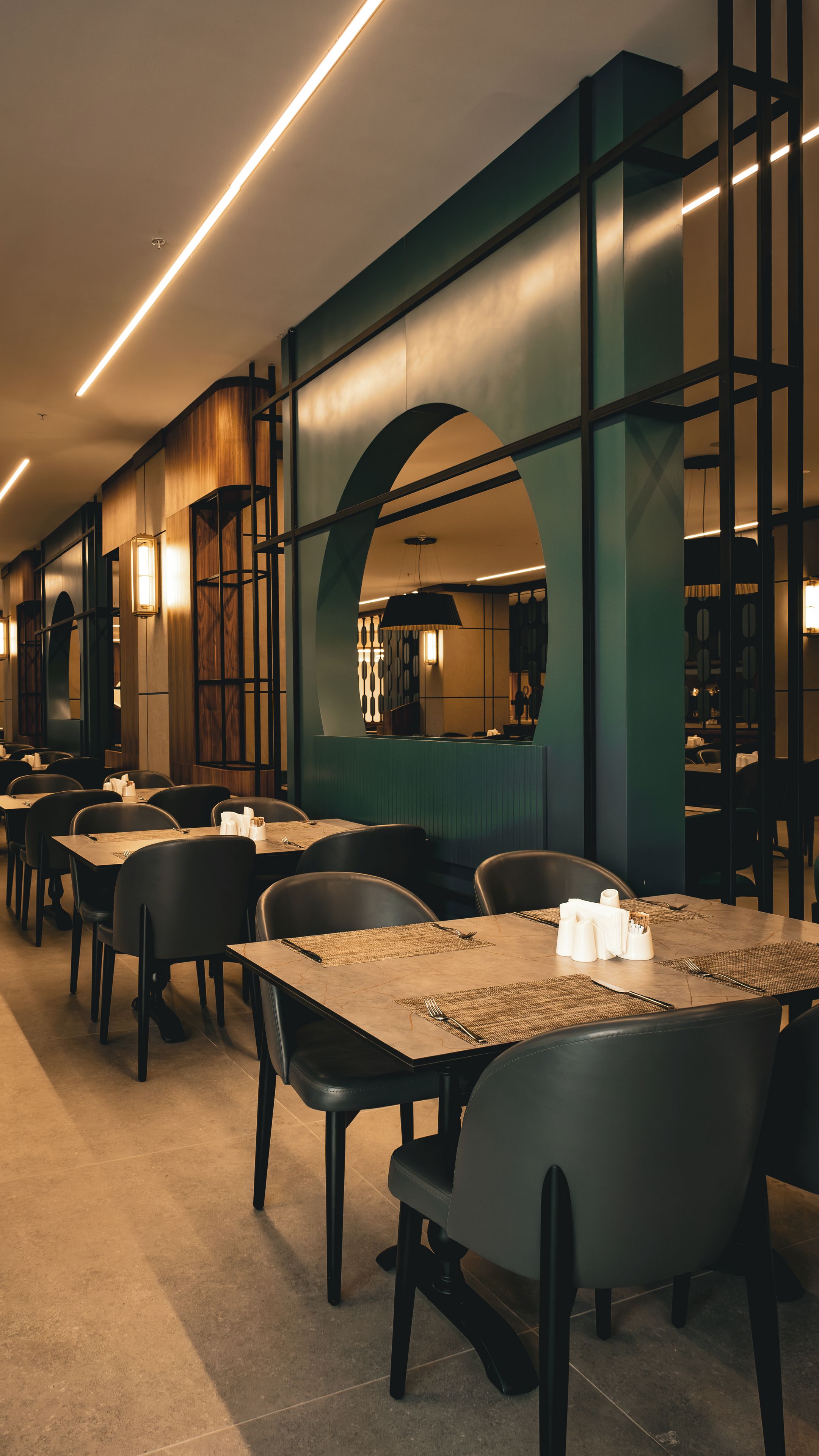 Un interior de restaurante con mesas, sillas y un diseño moderno.