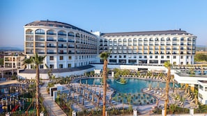 A hotel with multiple floors, a central pool area, and outdoor seating. - Raxeria Hotel - All Inclusive (Manavgat)