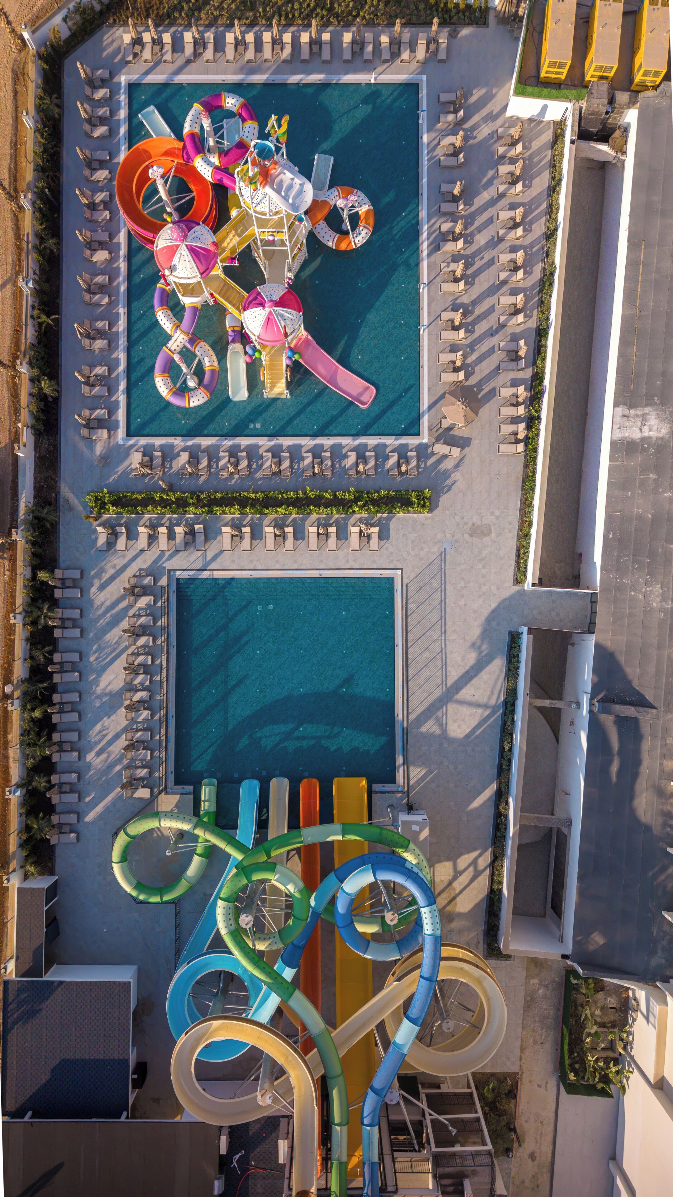 An aerial view of a pool area with multiple water slides and lounge chairs.
