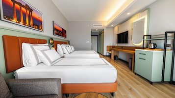 Habitación de hotel con dos camas, un escritorio, un televisor y una cafetera.