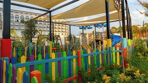 A playground with colorful play structures and a covered seating area.