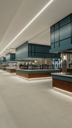 A modern kitchen with stainless steel appliances, teal cabinetry, and a clean, spacious layout. - Raxeria Hotel - All Inclusive (Manavgat)