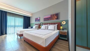 Habitación de hotel moderna con una cama grande, mesitas de noche, un escritorio y vistas a la ciudad.