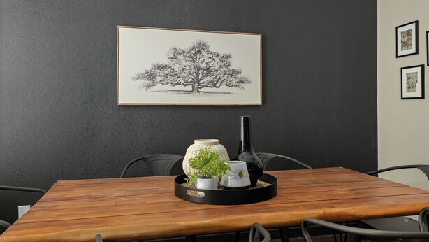 A dining table with a tray holding a vase, a mug, and a small plant. - Gothic Garden Bright, Cozy Escape with Modern Touches in Historic Bryan (Bryan)