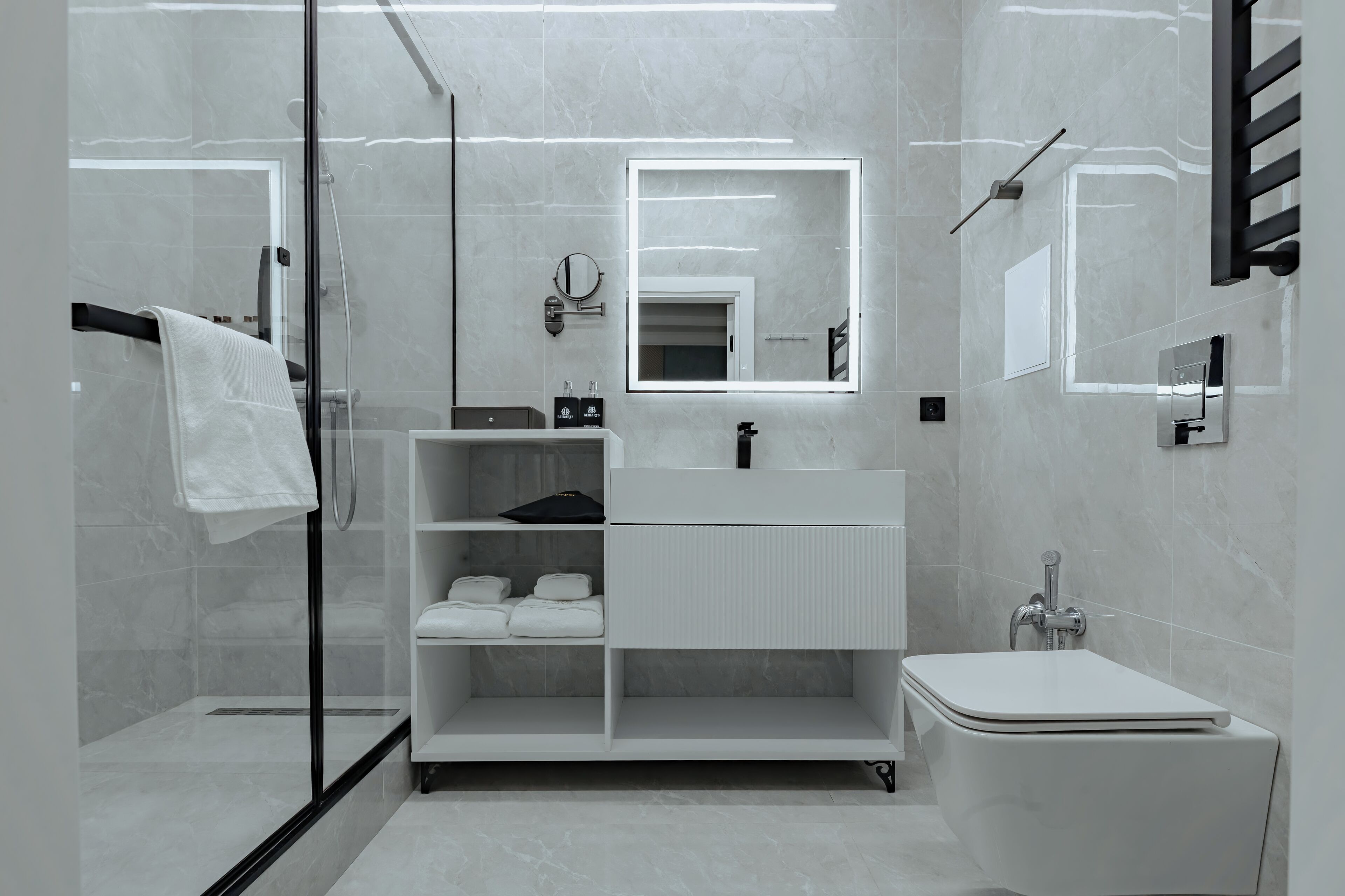 A modern bathroom with a glass shower enclosure, a white vanity with a mirror, and a toilet.
