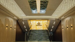 Un interior moderno con una escalera de mármol que lleva a una zona de recepción con el letrero 'BEIBARY'S'.