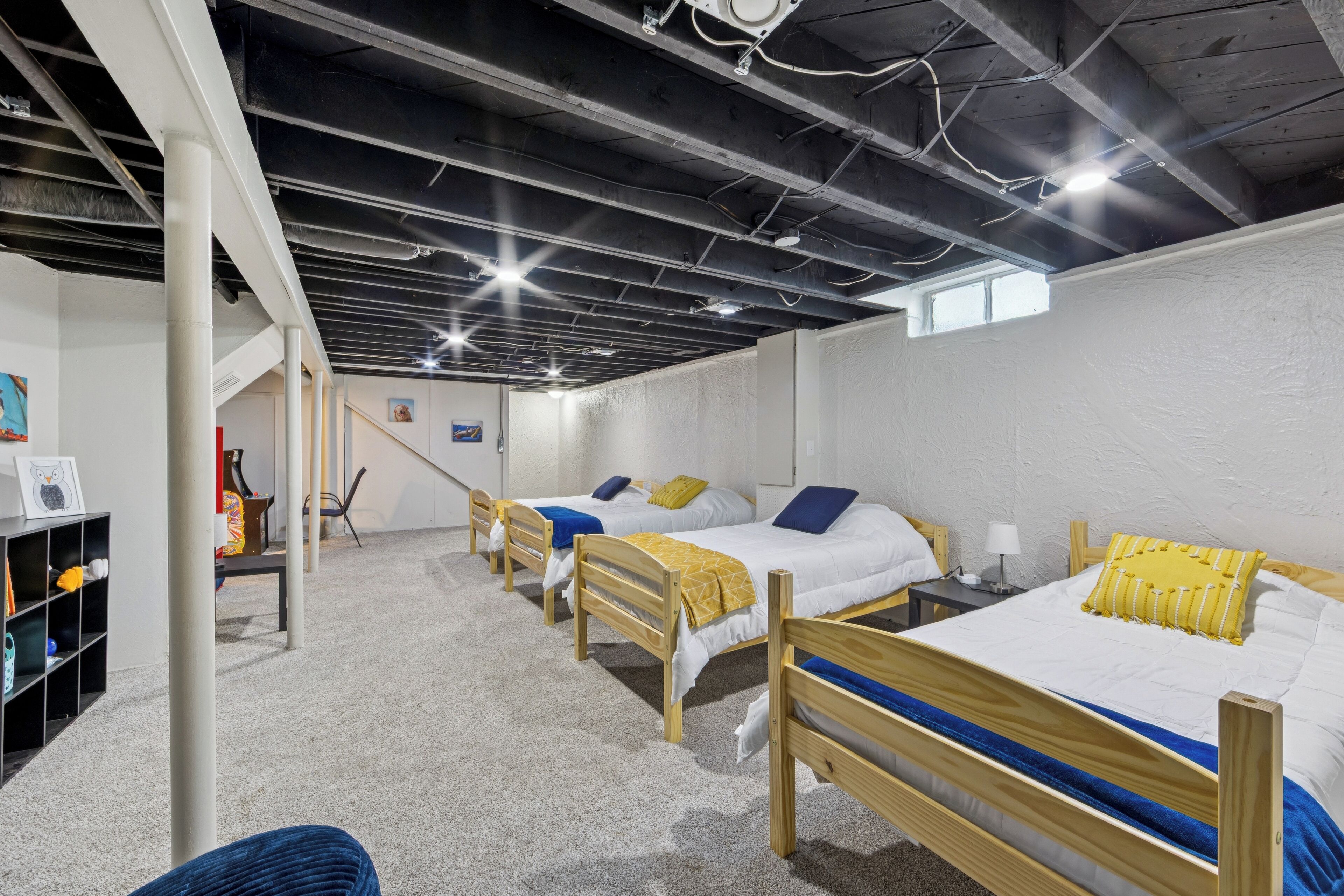 Ein Schlafsaalzimmer mit drei hölzernen Etagenbetten, einem Schreibtisch und einem Stuhl.