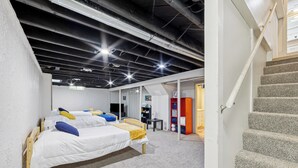 A hotel room with a bunk bed, a desk, and a staircase.