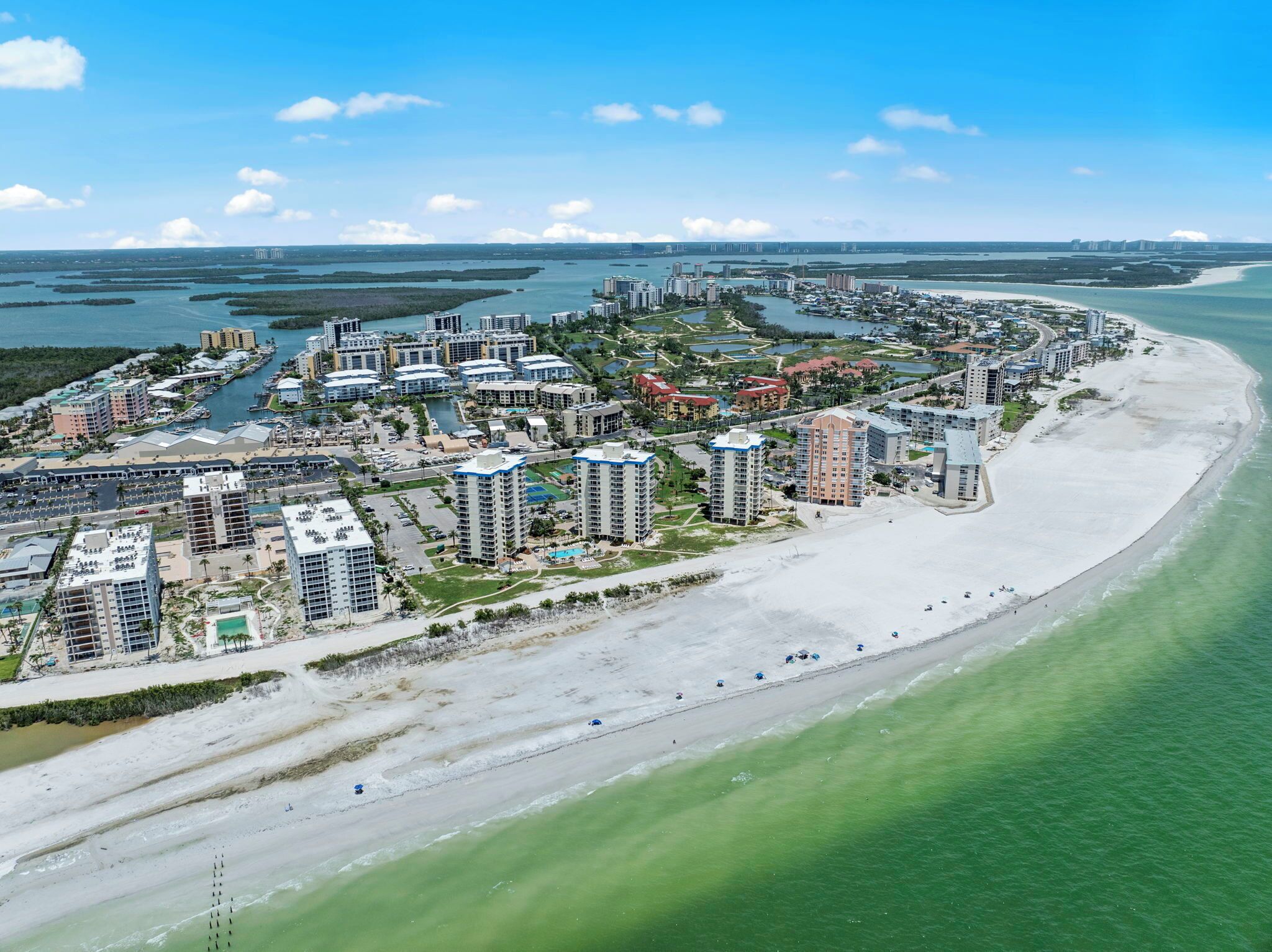 Une station balnéaire dotée de grands immeubles, d’une plage de sable et d’un port de plaisance.