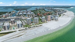 Una località balneare con edifici alti, una spiaggia sabbiosa e un porto turistico.