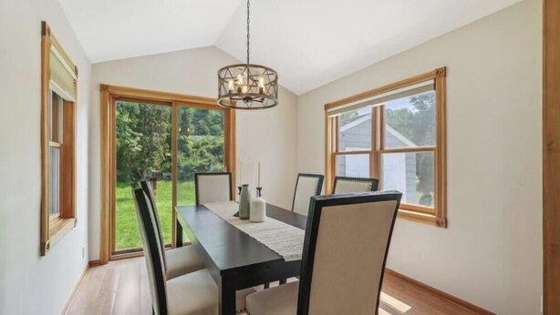 Une salle à manger avec une grande table, des chaises et un lustre.