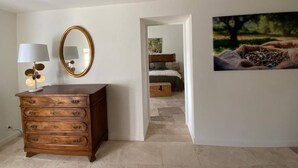 Un dormitorio con cama, cómoda, espejo y un cuadro en la pared.