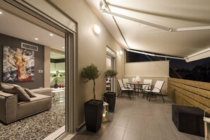 A modern living space with a sofa, a dining table with chairs, and a potted plant. - Ma Maison Penthouse No1, Acropolis view, Huge terrace, 315 Mbps (Athens)