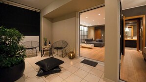 Un salon moderne avec un canapé, des fauteuils, une table basse et une plante en pot.