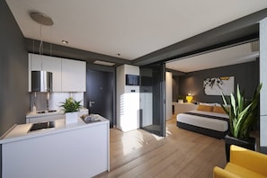 A modern apartment with a kitchen, a dining area, and a bedroom.