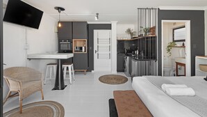 Un apartamento moderno y funcional con kitchenette, comedor y dormitorio.