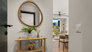 A modern interior with a wooden console table, a mirror, a potted plant, and a small elephant sculpture.