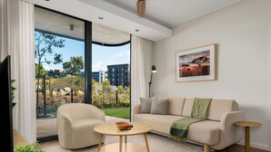 A modern living room with a sofa, a round coffee table, and a TV.