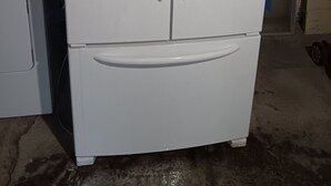 Et hvidt køleskab med frostboks ovenpå, håndtag og kontrolpanel på højre side.