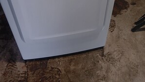 En hvid Samsung vaskemaskine med kontrolpanel, placeret i et rum med beton gulv.